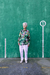 Portrait of smiling woman standing against wall
