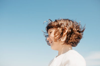 Low angle view of cute girl standing against sky