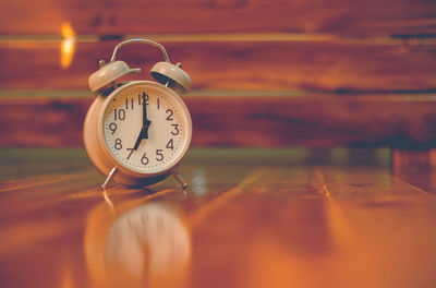 Close-up of alarm clock on wooden table