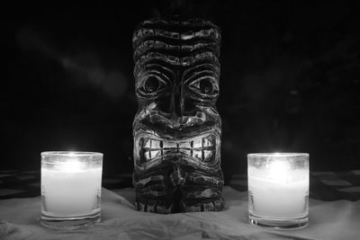 Close-up of lit candle on table