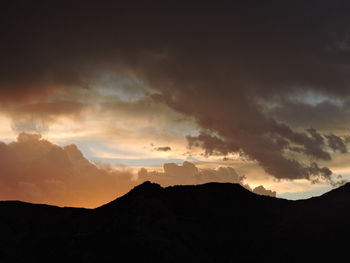 Scenic view of silhouette mountains against sky during sunset