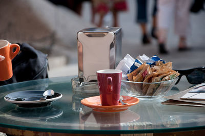 Coffee cup with sugar packets on table