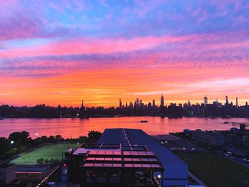 High angle view of river by buildings against sky during sunset