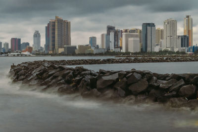 Silky breakwater and buildings against sky