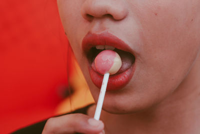 Close-up of woman mouth eating lollipop