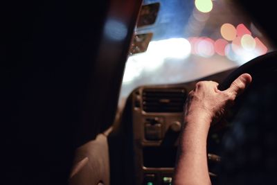 Midsection of man photographing illuminated mobile phone
