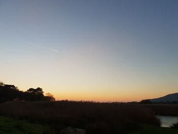 Silhouette landscape against clear sky during sunset