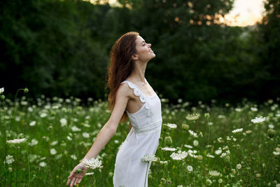 Side view of woman standing by plants