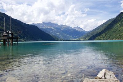Scenic view of lake by mountains against sky