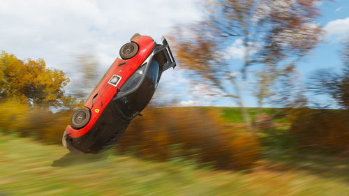 Red toy car on land against sky