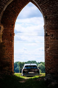 Car on stone wall against sky