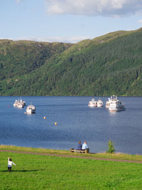 Boats sailing on sea against sky