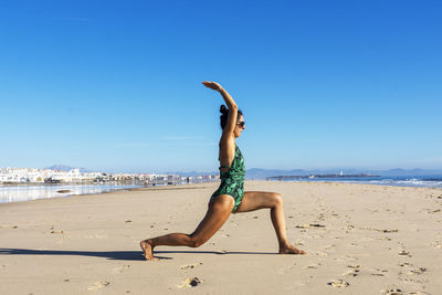 Yoga woman doing yoga pose on the beach for wellbeing health lifestyle.