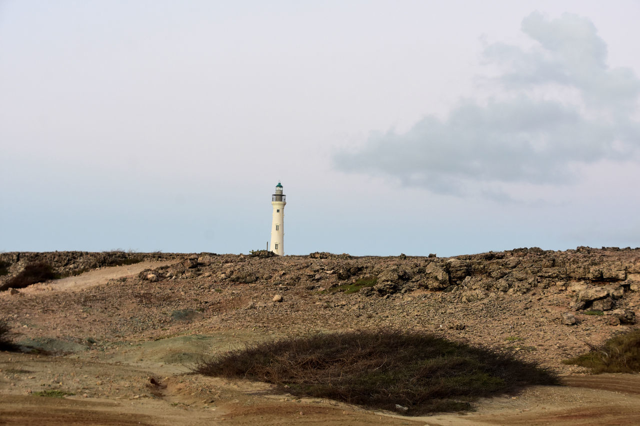lighthouse, guidance, tower, sky, architecture, built structure, sea, protection, building exterior, security, nature, coast, land, hill, building, landscape, environment, scenics - nature, day, non-urban scene, no people, travel destinations, natural environment, travel, sand, outdoors, rock, beach, cloud, copy space, water, sand dune, tranquility, beauty in nature