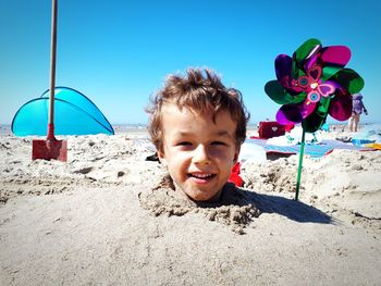 Cute boy on beach against sky