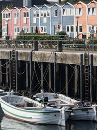 Boats moored in river by buildings in city