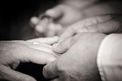 Cropped hand of bride putting ring on bridegroom during wedding ceremony