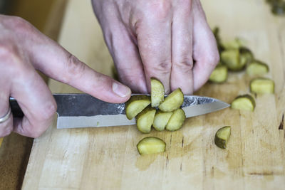 Cropped image of person preparing food on cutting board