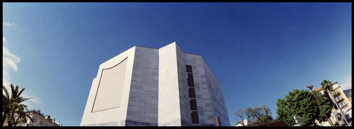 Low angle view of modern building against blue sky