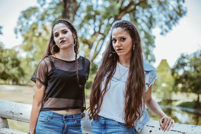 Portrait of smiling young women standing by railing