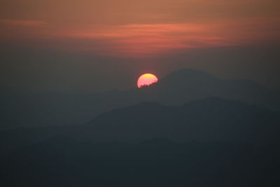 Scenic view of silhouette mountain against orange sky