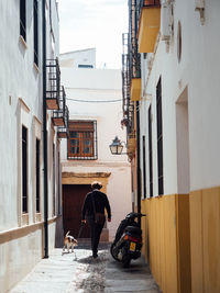 Rear view of person on street amidst buildings in city