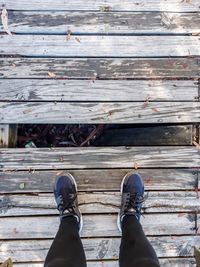 Low section of man standing on wooden pier