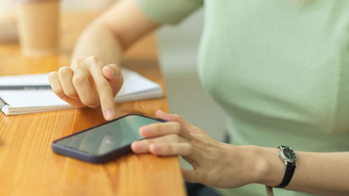 Midsection of woman using mobile phone