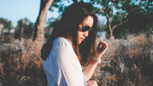 Portrait of young woman wearing sunglasses standing outdoors