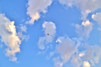 Low angle view of birds flying against blue sky