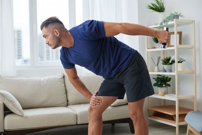 Side view of man exercising at home