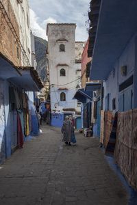 Footpath amidst buildings against sky