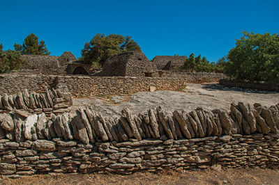 Typical hut made of stone with walled fence at the village of bories, near gordes, france.