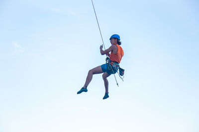 Low angle view of man paragliding against sky