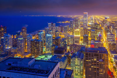 High angle view of illuminated buildings against sky at night