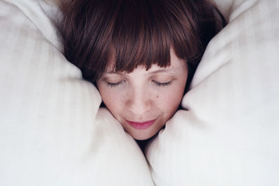 Close-up of young woman sleeping on bed at home