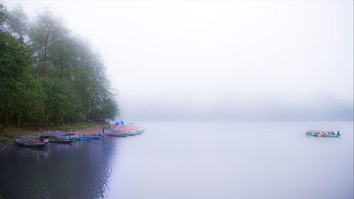 Boats moored on river against sky