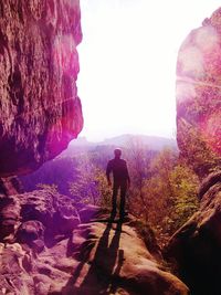 Rear view of man walking on rocks