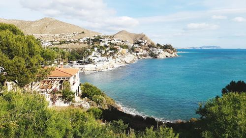 High angle view of townscape by sea against sky