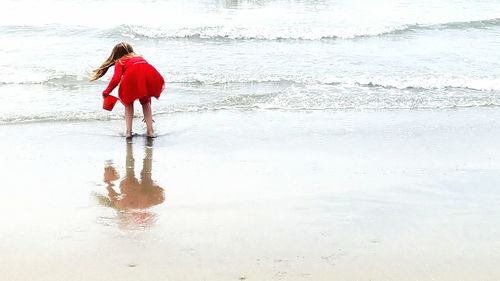 Rear view of woman standing on beach