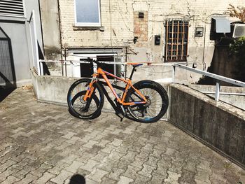 Bicycle parked on street amidst buildings