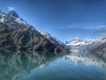 Scenic view of lake and mountains against blue sky