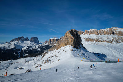 People on snowcapped mountain against sky