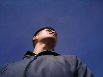 Portrait of young man against blue sky