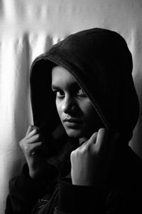 Portrait of beautiful young woman against wall