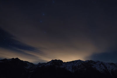 Scenic view of silhouette mountains against sky at night