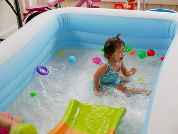 High angle view of girl crying in wading pool