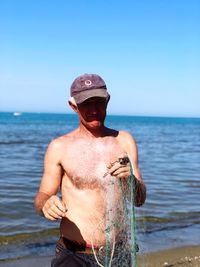 Close-up of man at beach against sky