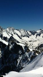 Scenic view of snow covered mountains against clear sky