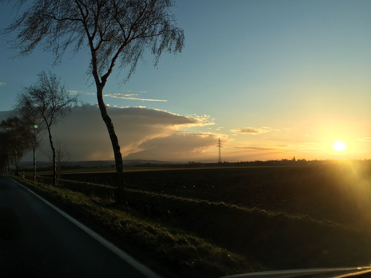 road, transportation, the way forward, sky, tree, sunset, landscape, country road, tranquility, tranquil scene, road marking, silhouette, field, nature, scenics, empty road, street, diminishing perspective, beauty in nature, sun